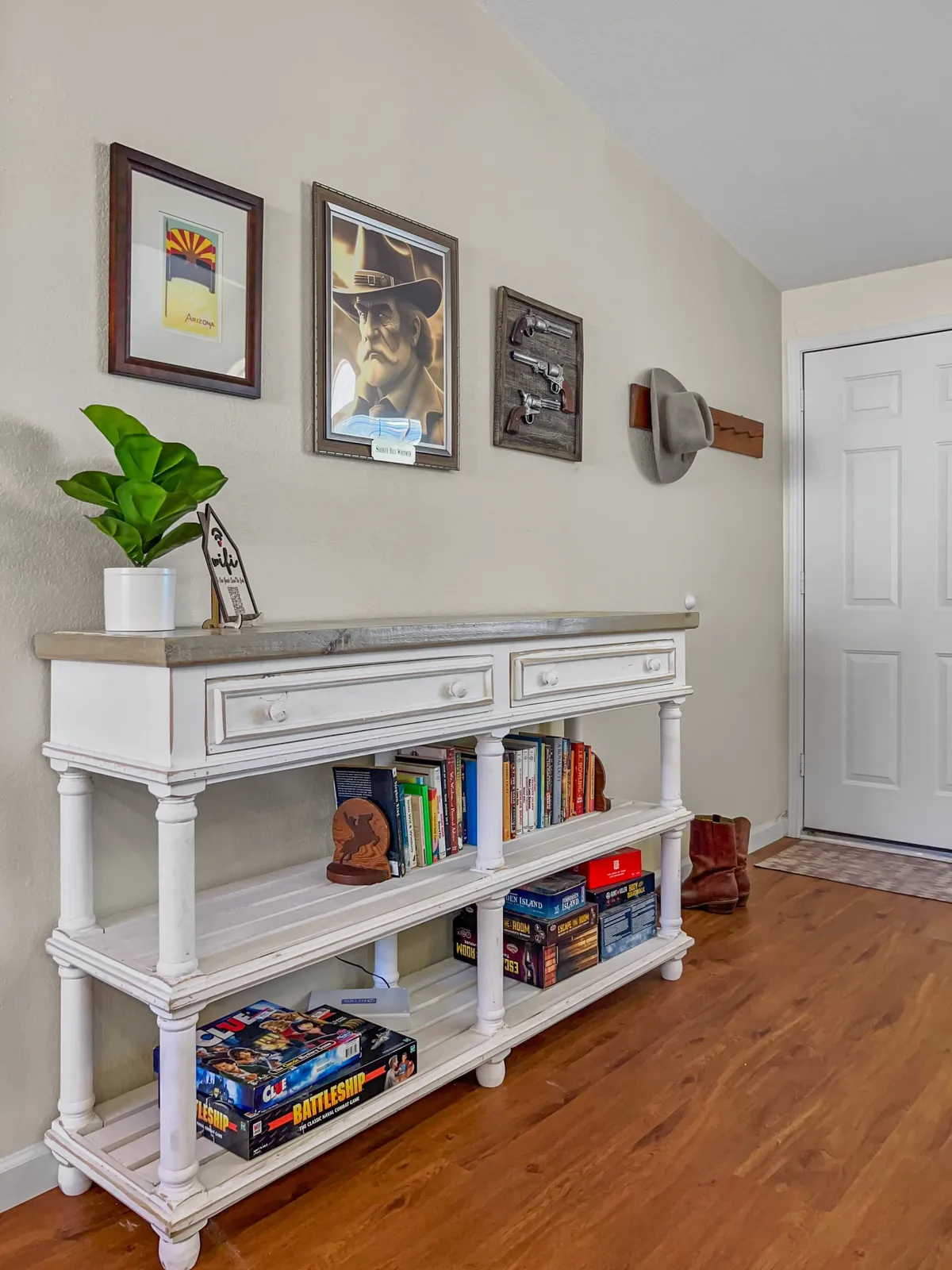 An interior view showcasing a stylish console table, vibrant artwork on the wall, and a leafy plant, all arranged to create a cozy yet inspiring atmosphere. The area feels suitable for reading, brainstorming, or casual work sessions.